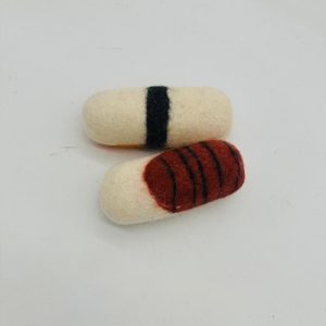 A handmade felt turtle pet toy with a green body and yellow shell spots, featuring small white eyes.